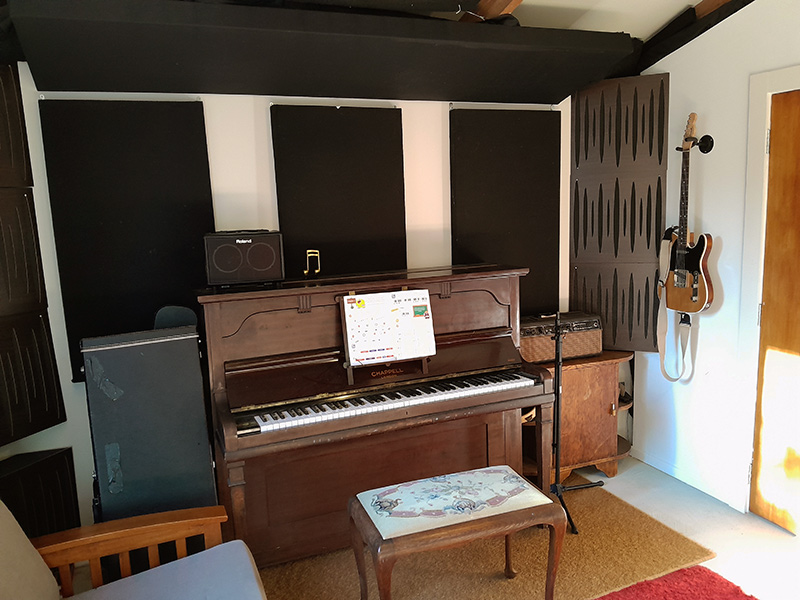 piano and guitar in well lit recording studio in Auckland