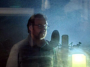 voice narrator seen through glass of recording booth